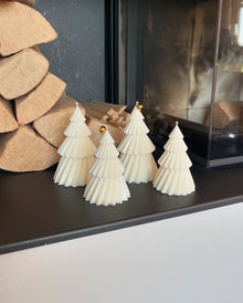 Tres árboles Nórdicos de La Marie en crema, frente a leños de madera