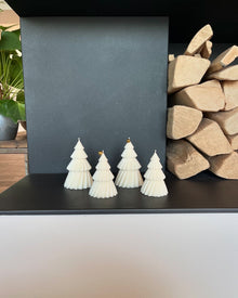 Árboles Nórdicos de La Marie en crema, en fila frente a leños de madera