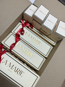 Cajas de regalo de La Marie con lazo rojo, empacadas en una caja de envío