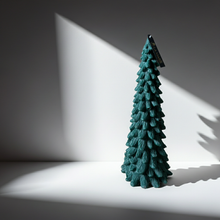 Pino verde de La Marie sobre fondo gris, con un haz de luz y su sombra