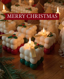 Cubos navideños de La Marie encendidos entre ramas de pino