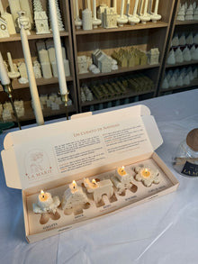Cinco velas navideñas encendidas en la Caja de Luz: galleta, árbol, reno, hombre de jengibre y copo de nieve