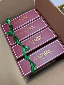 Cajas de regalo de La Marie con lazo verde, empacadas en una caja de envío