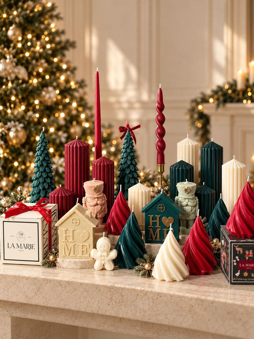 Velas navideñas de La Marie en rojo, verde y crema: árboles, casas HOME y cascanueces frente a un árbol con luces
